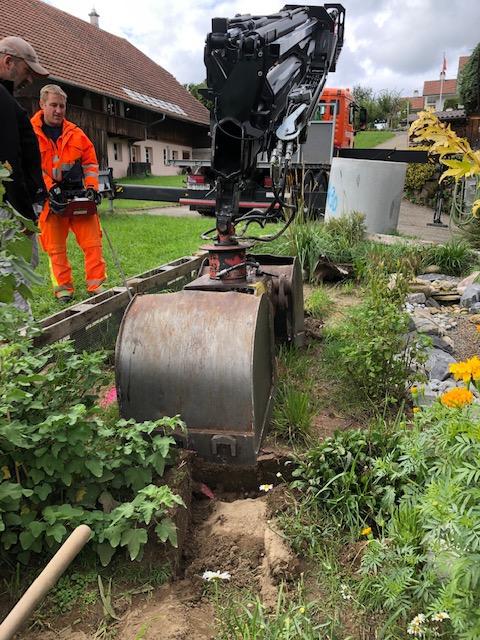 Kran beim Setzen des Betonschachtes