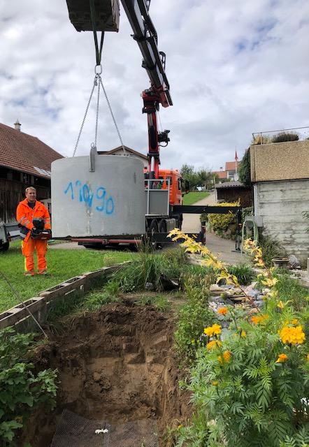 Kran beim Setzen des Betonschachtes